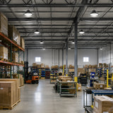 100-150W selectable 23,100lm 4000K-5000K UFO LED high bay lights illuminate a warehouse with racks.