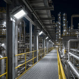 Row of 150W C1D1 square LED explosion proof flood lights delivering 21,000 lumens of 5000K illumination along a refinery walkway.