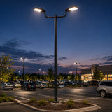 2-arm steel bullhorn bracket mounted on a pole with two area lights in a parking lot