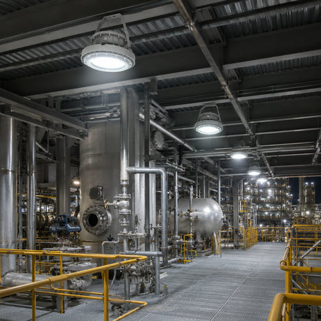 Row of 200W C1D1 round LED high bay lights delivering 28,000 lumens of 5000K illumination in an industrial processing plant.
