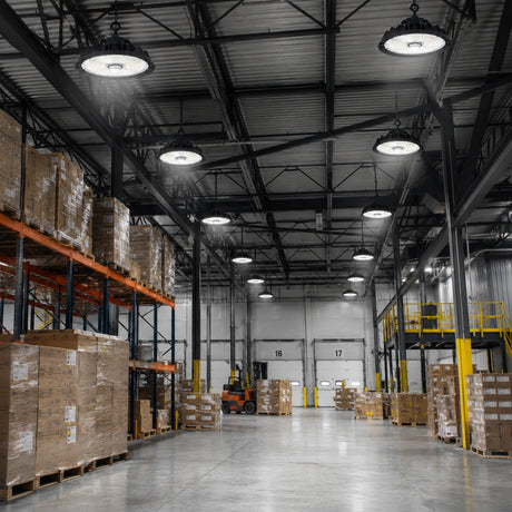 240-310W 47,430lm 5000K dimmable UFO LED high bay lights illuminate a spacious warehouse with racks.