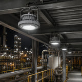 Row of 80W C1D1 round LED explosion proof high bay lights providing 4000K illumination in a refinery walkway.