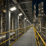 Row of 80W C1D1 square LED explosion proof flood lights delivering 11,200 lumens of 4000K illumination along a refinery walkway.