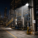 C1D2 explosion proof square flood light 60W illuminating outdoor petrochemical refinery at night with pressure vessels and C1D2 hazard sign, 8400lm