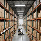 225W selectable LED linear high bay lights illuminating a large warehouse aisle with high racking and forklift.